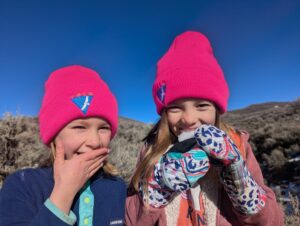 Two girls wearing the bright pink hats of Volo, an alternative to Private School near Park City.