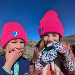 Two girls wearing the bright pink hats of Volo, an alternative to Private School near Park City.